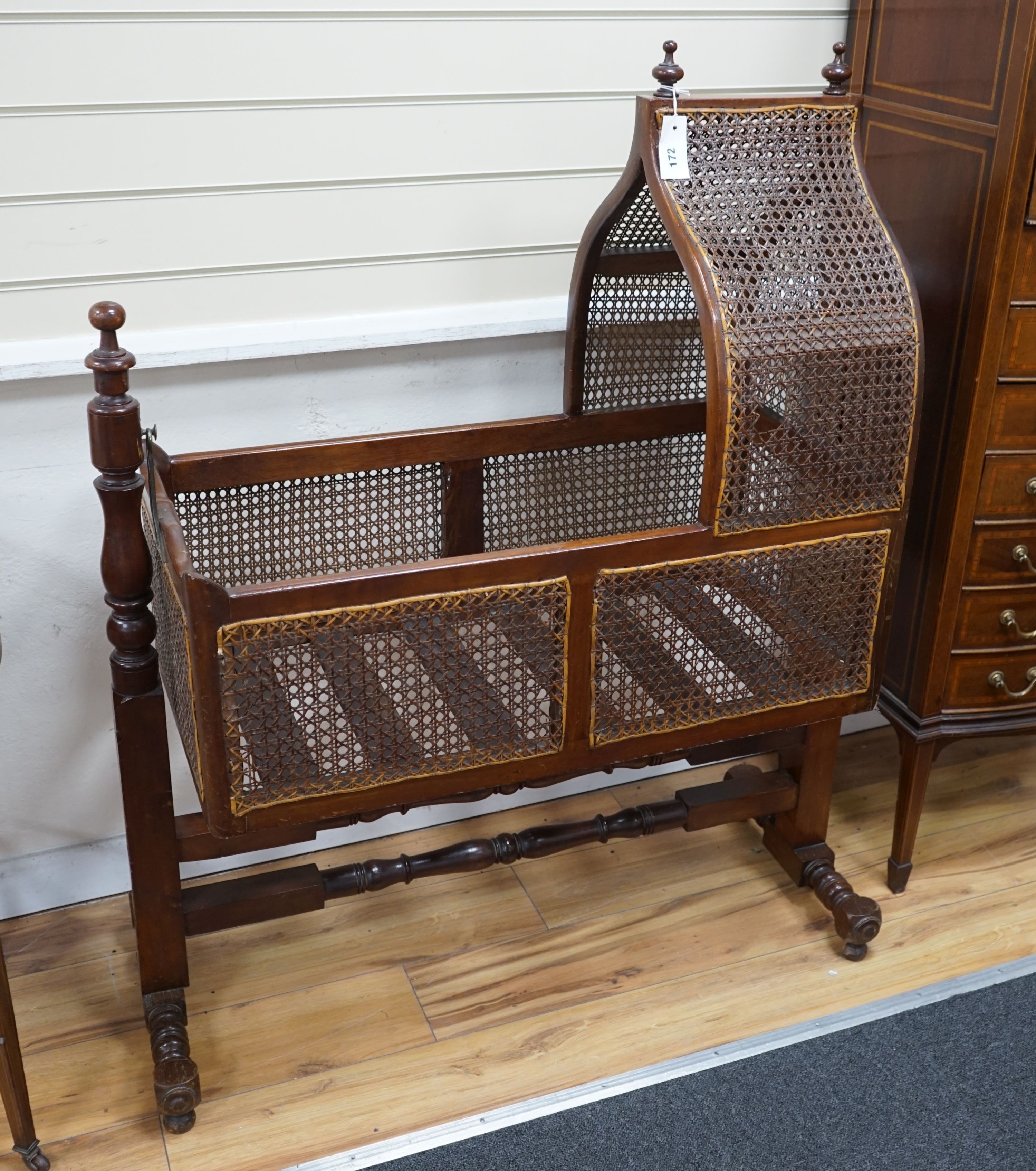 A Victorian caned mahogany rocking cradle with arched canopy, width 100cm, depth 41cm, height 124cm